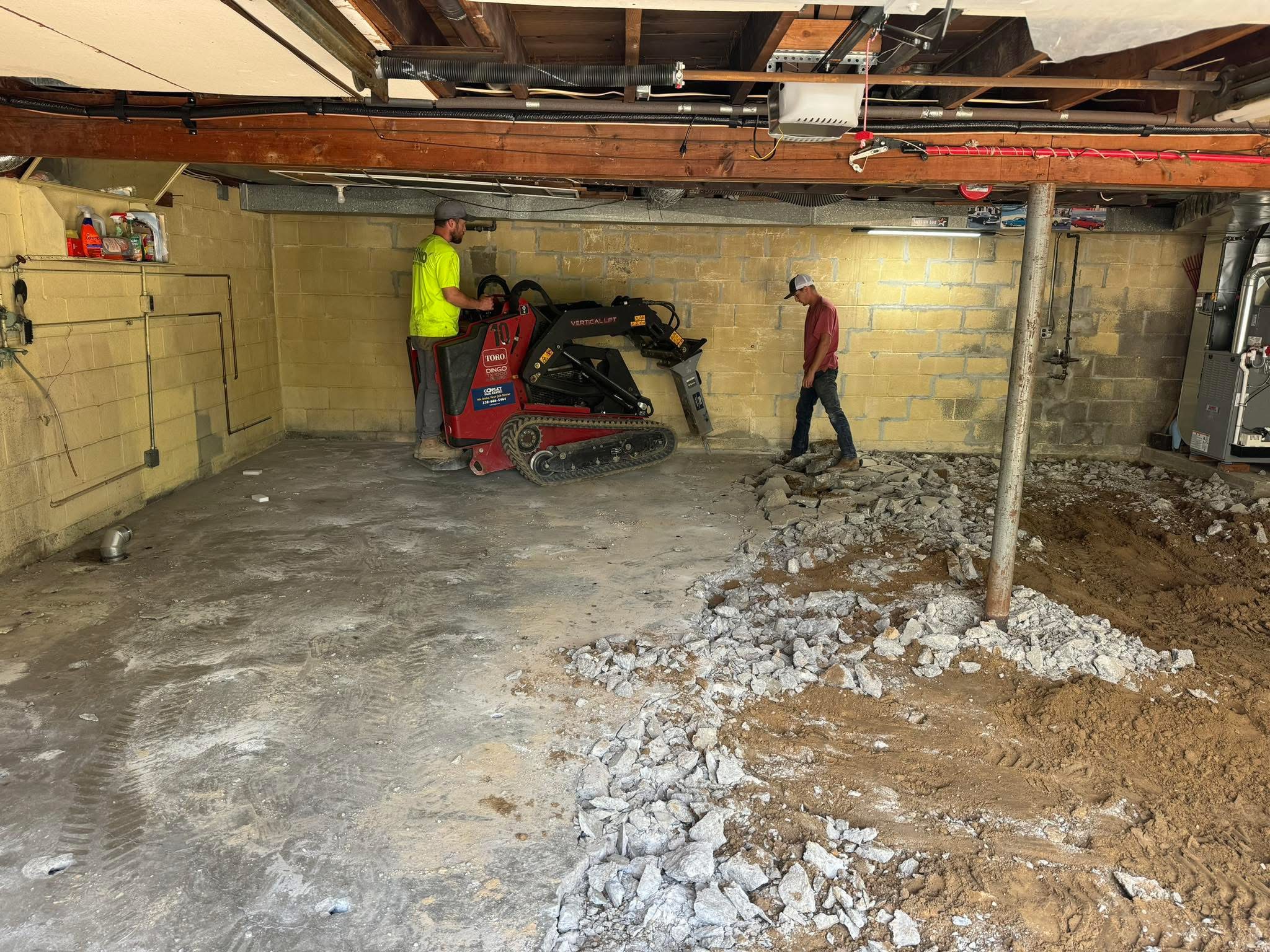 Basement concrete floor demolition with a compact track loader and jackhammer